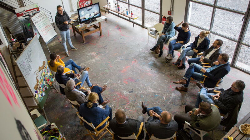 Philipp Klietz diskutiert mit Mitgliedern der Dienstleistungsgenossenschaft Eifel über Filme in der Unternehmenskommunikation.